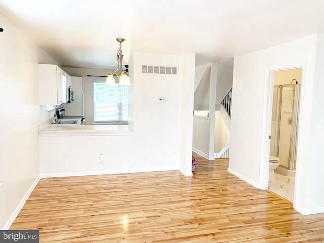 interior space featuring sink, an inviting chandelier, and light wood-type flooring