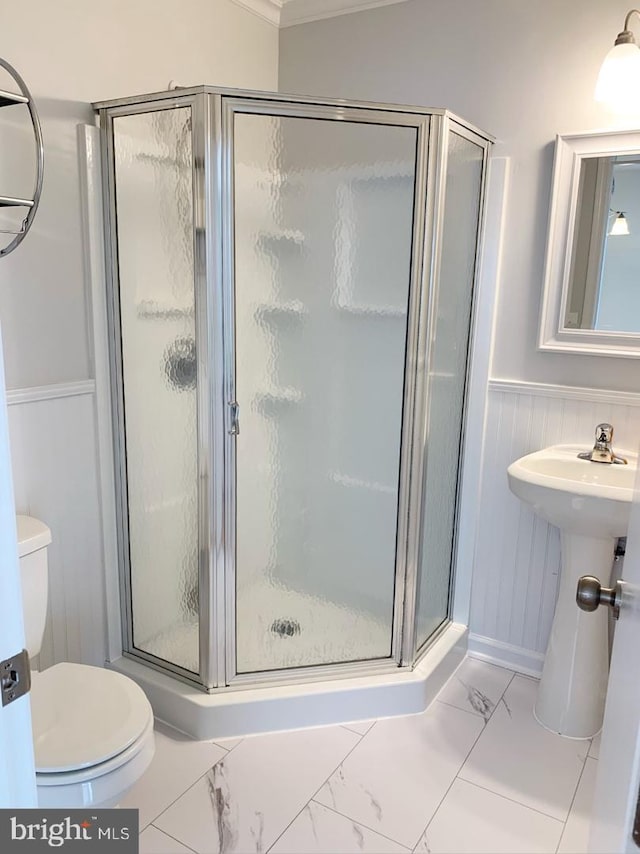 bathroom with toilet, walk in shower, ornamental molding, and wood walls