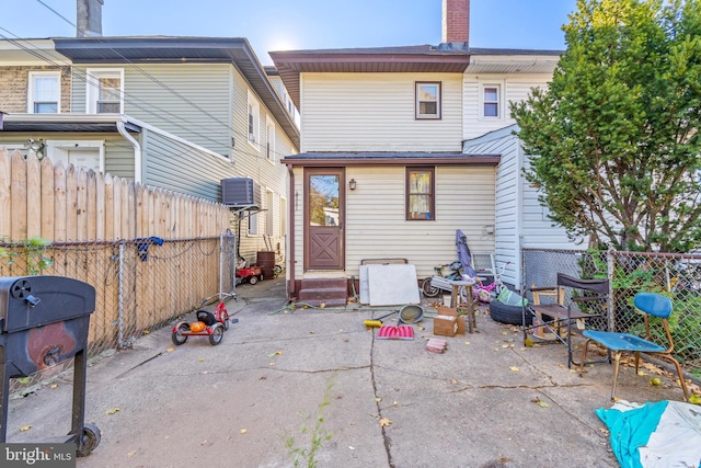 back of property with a patio and central AC