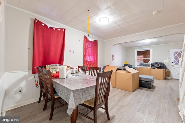 dining space with crown molding and wood-type flooring