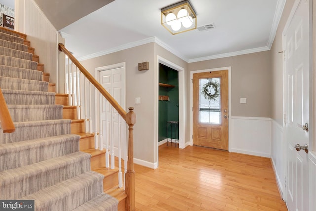 entryway featuring crown molding and light hardwood / wood-style floors