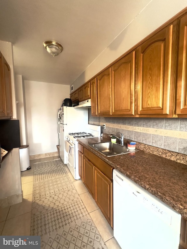 kitchen featuring decorative backsplash, light tile patterned flooring, white appliances, and sink