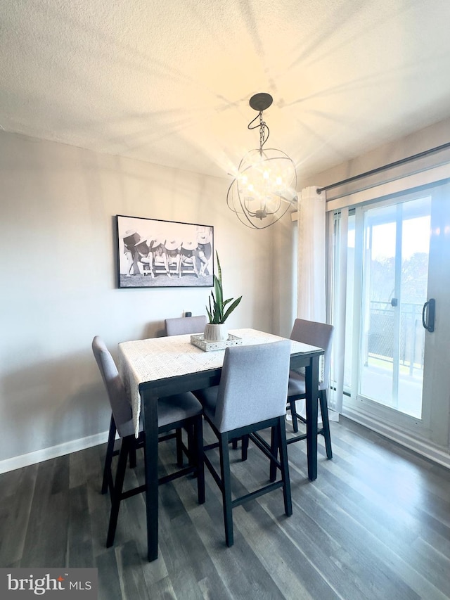 dining room featuring dark hardwood / wood-style flooring, a textured ceiling, and a notable chandelier