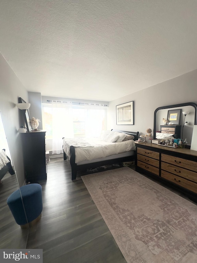 bedroom featuring dark hardwood / wood-style floors and a textured ceiling