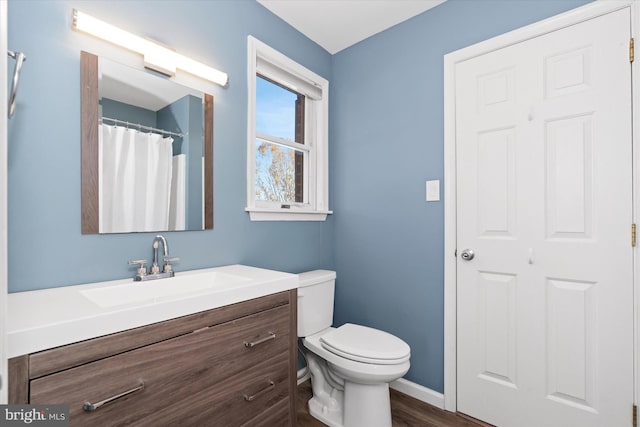 bathroom with vanity, wood-type flooring, and toilet