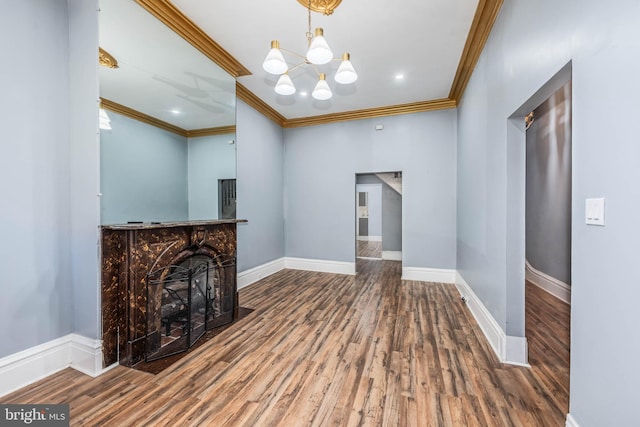 unfurnished living room featuring a notable chandelier, wood-type flooring, and crown molding