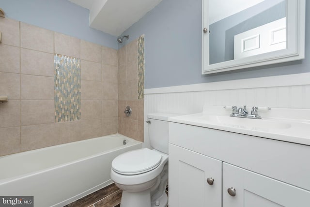 full bathroom with vanity, wood-type flooring, tiled shower / bath combo, and toilet