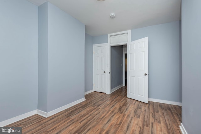 unfurnished bedroom with dark hardwood / wood-style flooring