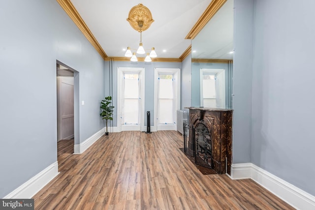 foyer entrance featuring crown molding, hardwood / wood-style floors, and a chandelier