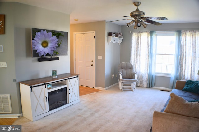 living room featuring ceiling fan and light hardwood / wood-style flooring