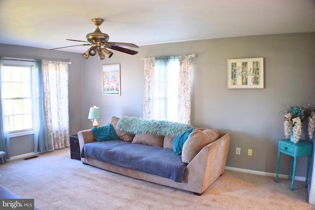 carpeted living room with a wealth of natural light and ceiling fan