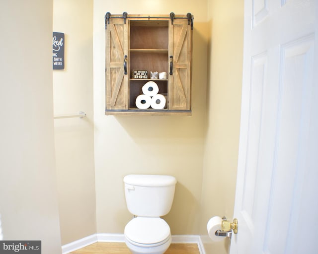 bathroom with hardwood / wood-style floors and toilet