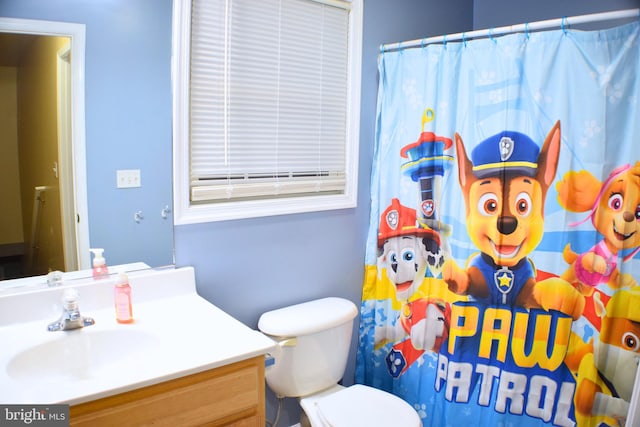 bathroom featuring a shower with curtain, vanity, and toilet