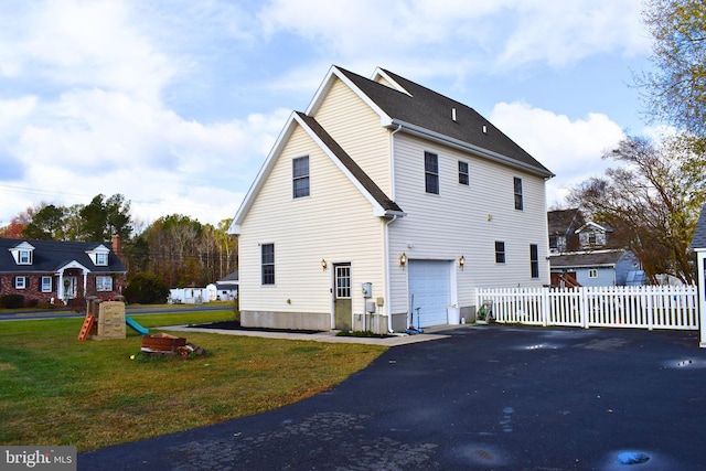 exterior space with a lawn, a garage, and a playground