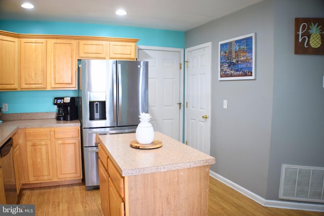 kitchen featuring a center island, light hardwood / wood-style floors, light brown cabinets, and appliances with stainless steel finishes