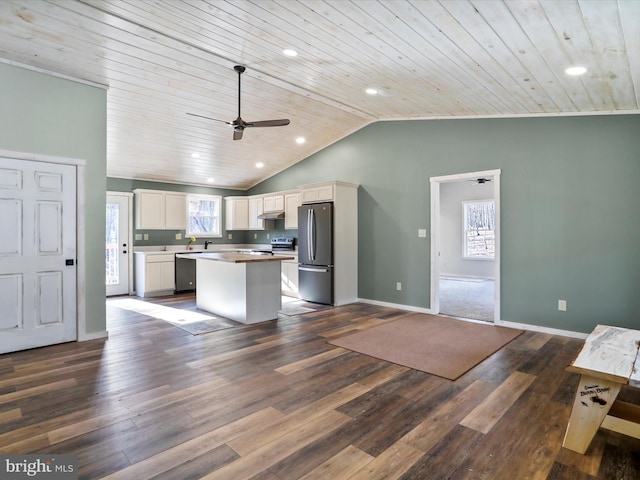 kitchen with white cabinets, ceiling fan, appliances with stainless steel finishes, a kitchen island, and dark hardwood / wood-style flooring