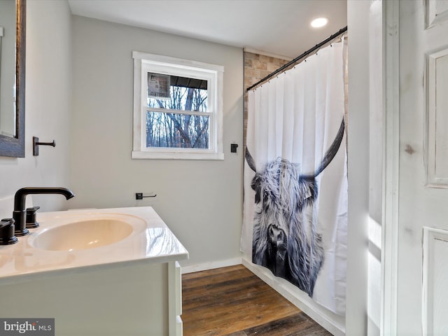 bathroom with hardwood / wood-style flooring, vanity, and curtained shower