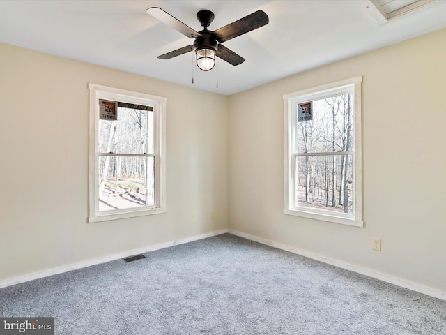 carpeted spare room featuring ceiling fan