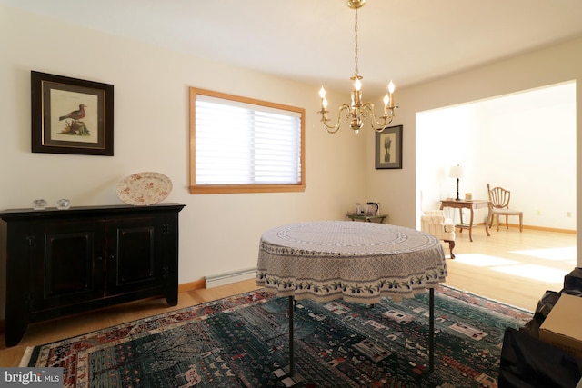 dining room featuring an inviting chandelier, wood-type flooring, and baseboard heating