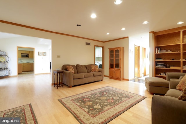 living room with light hardwood / wood-style flooring and ornamental molding