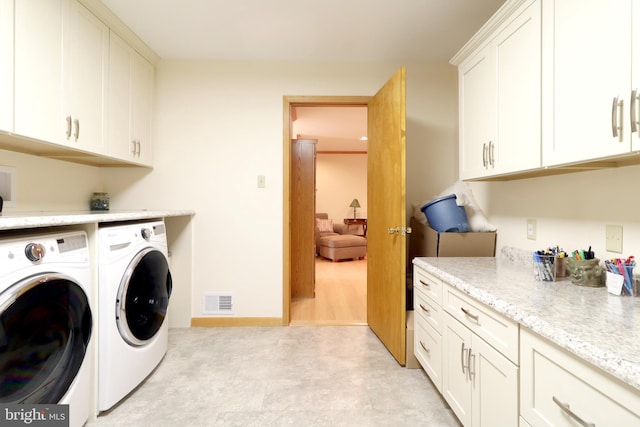 washroom featuring cabinets and washing machine and clothes dryer