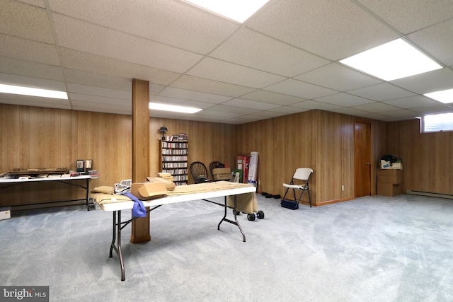 game room with carpet, a drop ceiling, and wood walls