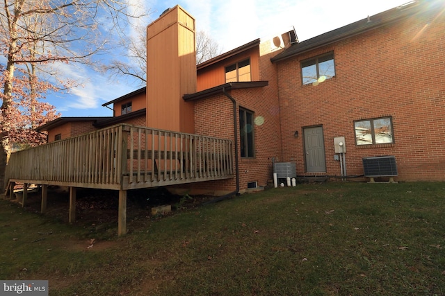 rear view of house with a yard, central AC unit, and a deck