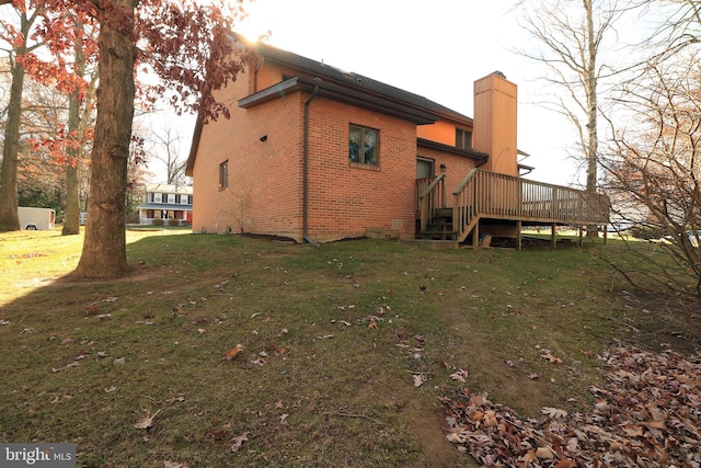 back of house featuring a deck and a lawn