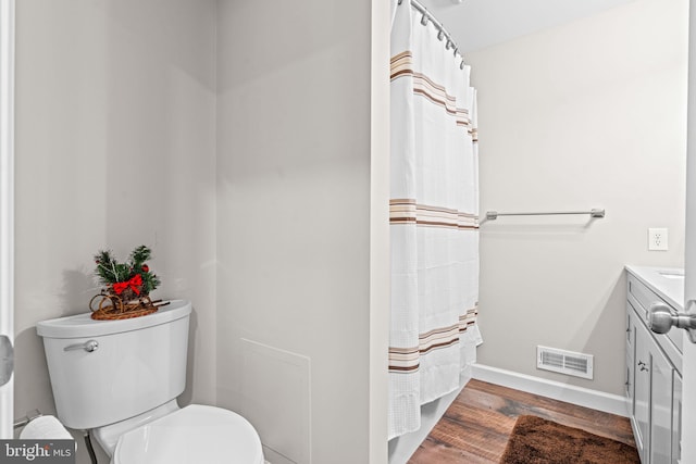 bathroom with a shower with shower curtain, vanity, hardwood / wood-style flooring, and toilet