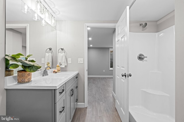 bathroom featuring vanity, wood-type flooring, and walk in shower