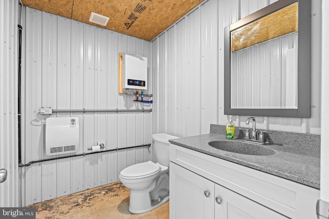 bathroom with vanity, heating unit, water heater, toilet, and wood walls