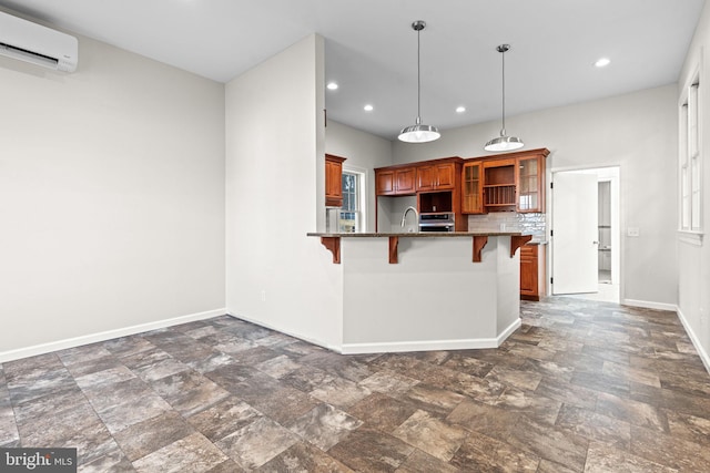 kitchen featuring decorative backsplash, kitchen peninsula, a breakfast bar, a wall unit AC, and hanging light fixtures