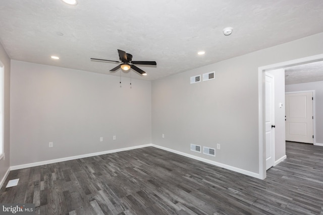 spare room with ceiling fan, dark wood-style floors, and visible vents