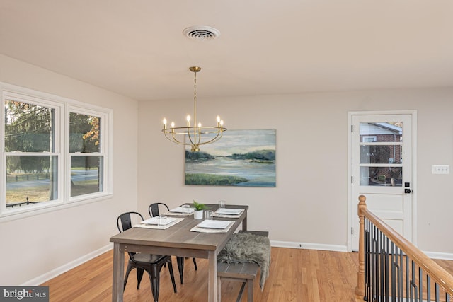 dining space featuring light hardwood / wood-style flooring and a notable chandelier