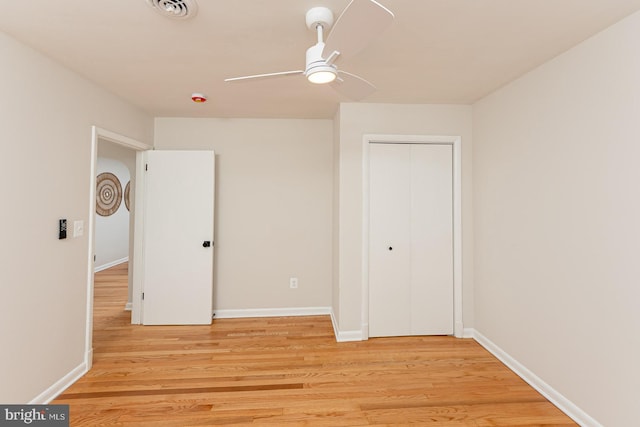 unfurnished bedroom with ceiling fan, a closet, and light wood-type flooring