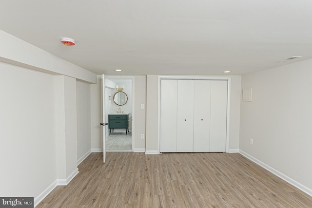 unfurnished bedroom with light hardwood / wood-style flooring, a closet, and sink