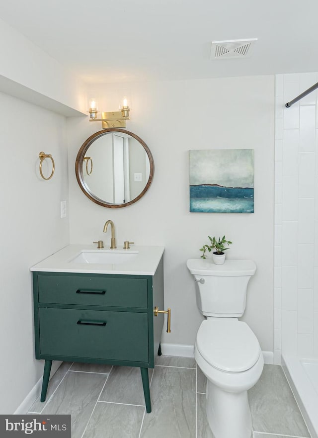 bathroom featuring tiled shower, vanity, and toilet