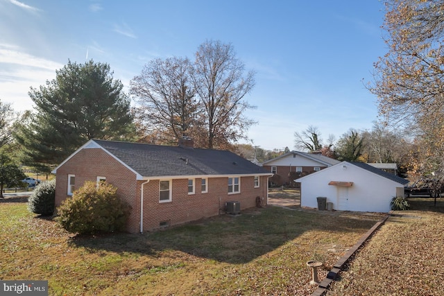 view of side of property with central AC and a yard