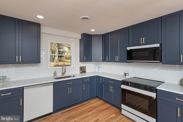 kitchen featuring range, sink, white dishwasher, blue cabinets, and light hardwood / wood-style floors