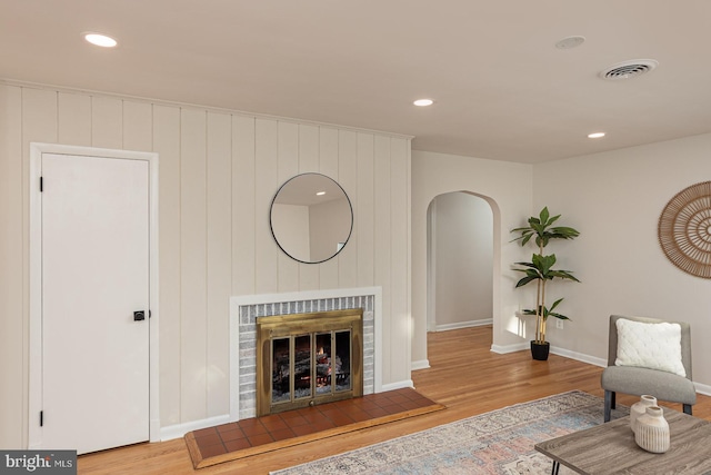 living room with a fireplace and light wood-type flooring