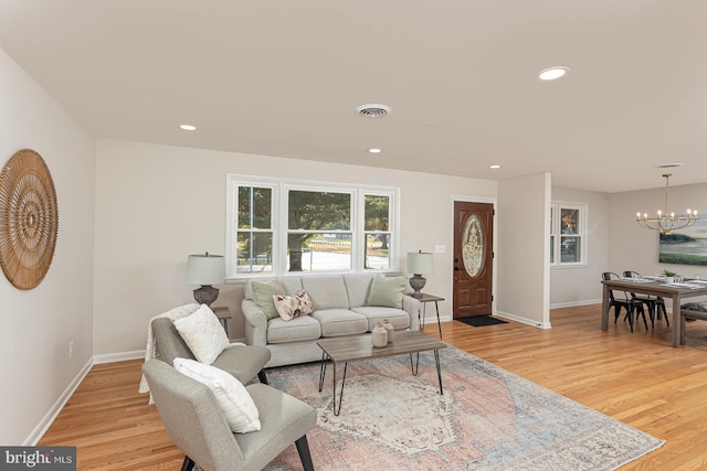 living room featuring a chandelier and light wood-type flooring