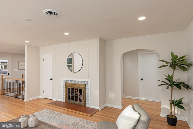 living room featuring hardwood / wood-style floors and a brick fireplace