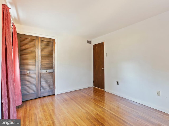 unfurnished bedroom featuring light hardwood / wood-style floors and a closet