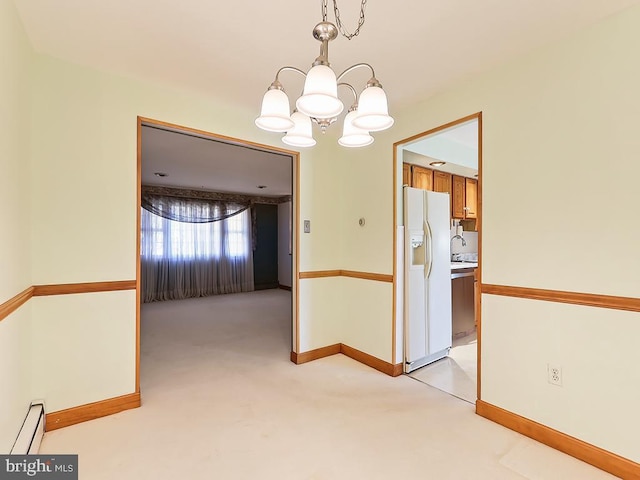 unfurnished dining area with a notable chandelier, light colored carpet, sink, and a baseboard heating unit