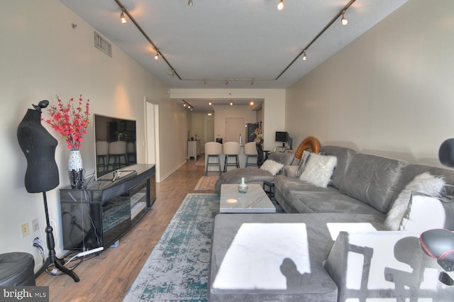 living room with wood-type flooring and track lighting