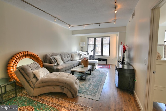 living room with hardwood / wood-style floors, rail lighting, and a textured ceiling