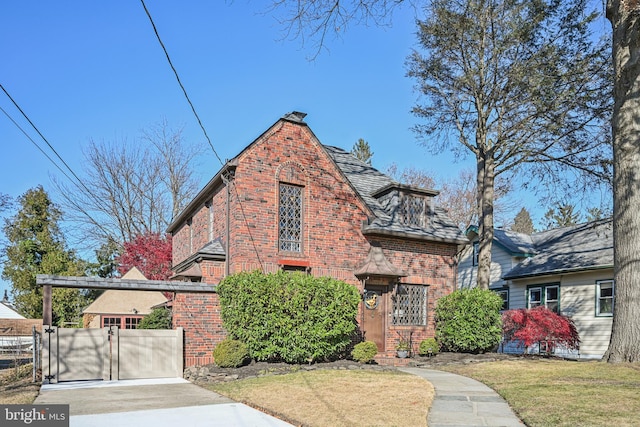 english style home with a front lawn