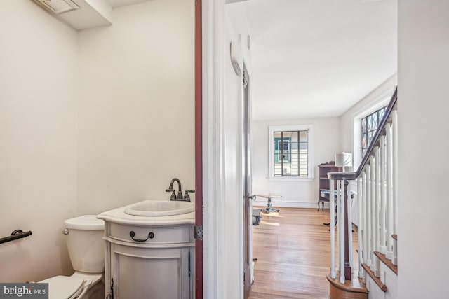 bathroom featuring toilet, vanity, and hardwood / wood-style flooring