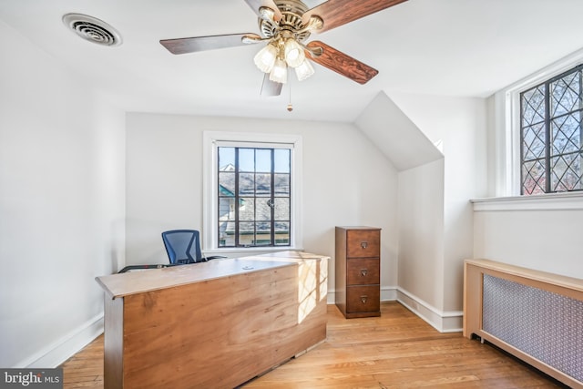 office with ceiling fan, radiator heating unit, and light hardwood / wood-style flooring