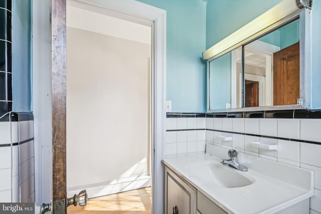 bathroom featuring vanity and tile walls